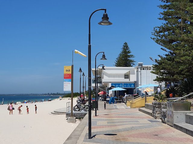 Brighton-Le-Sands beach promenade with kiosk and palm trees