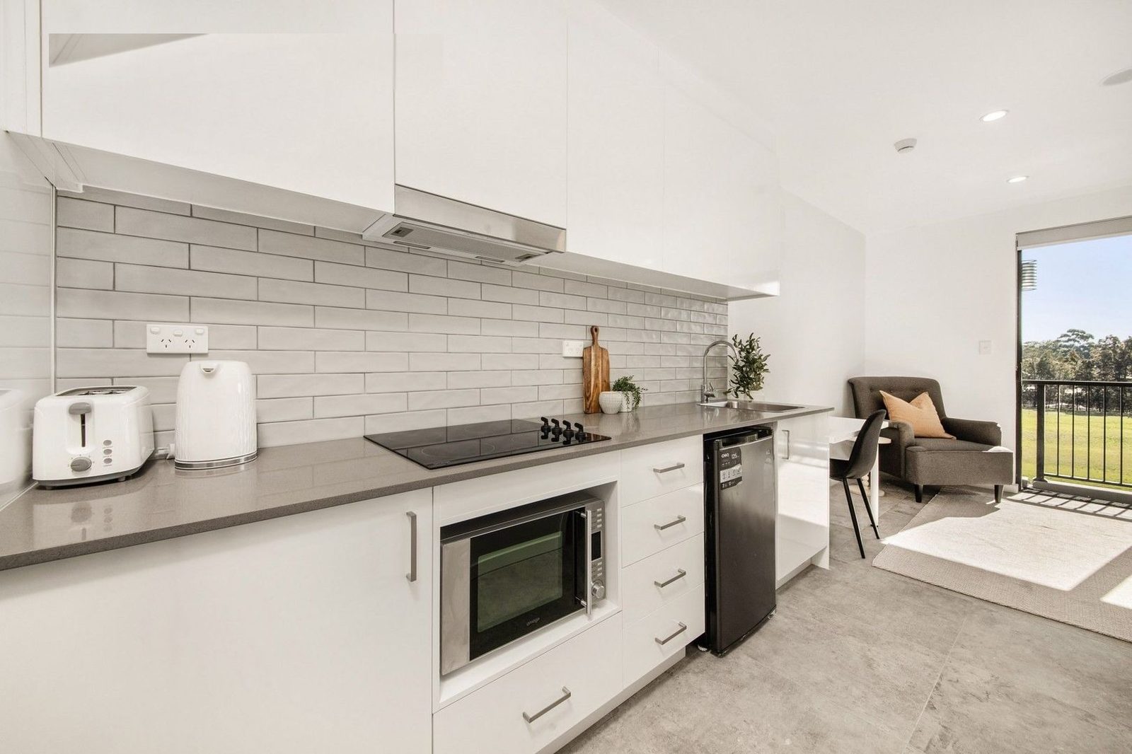 A Core Supports studio with fully-equipped kitchenette, living area and balcony view